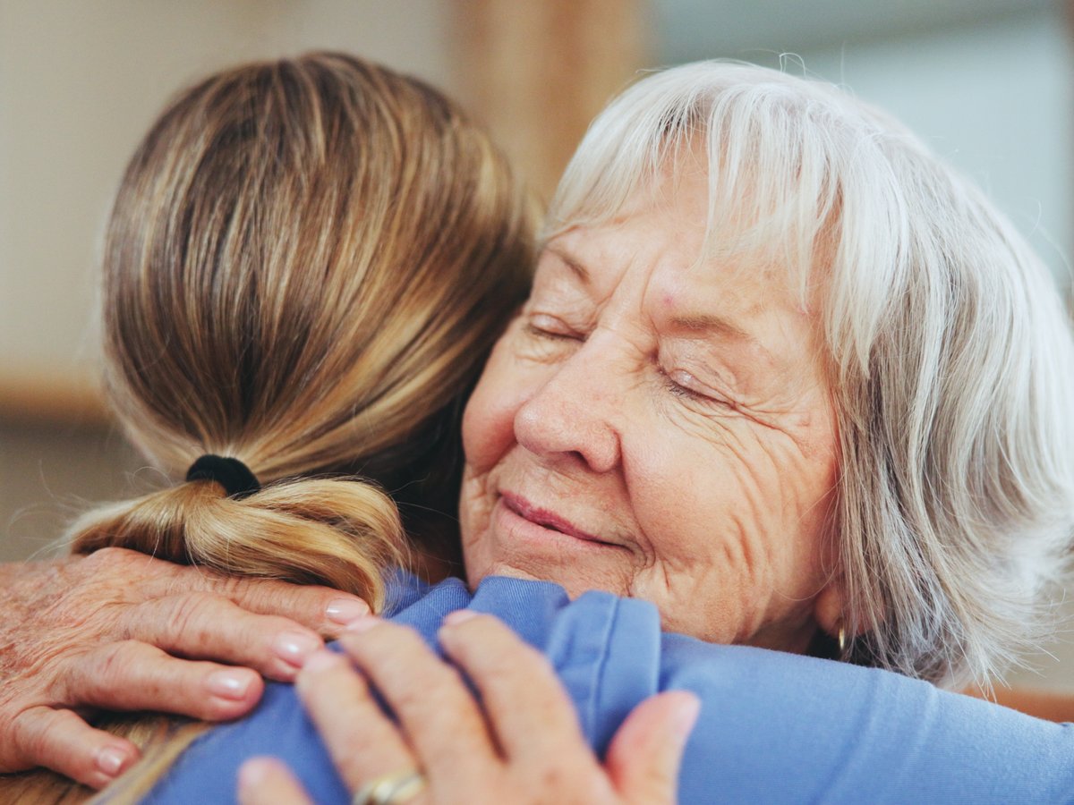 Senior adult day care participant embracing the on-site registered nurse