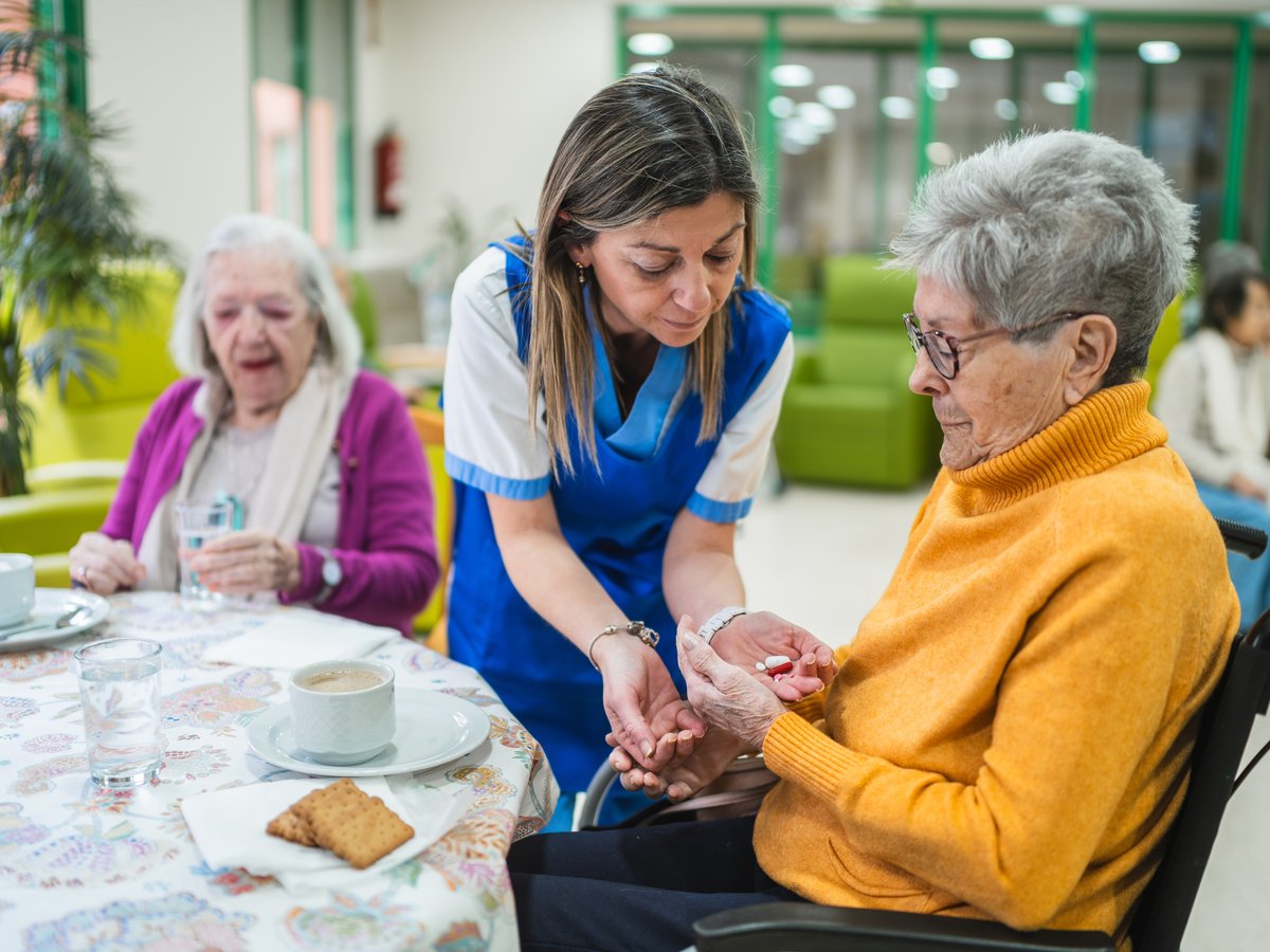 Nurse administering medication to a participant at an adult day care in Port Richey, Florida