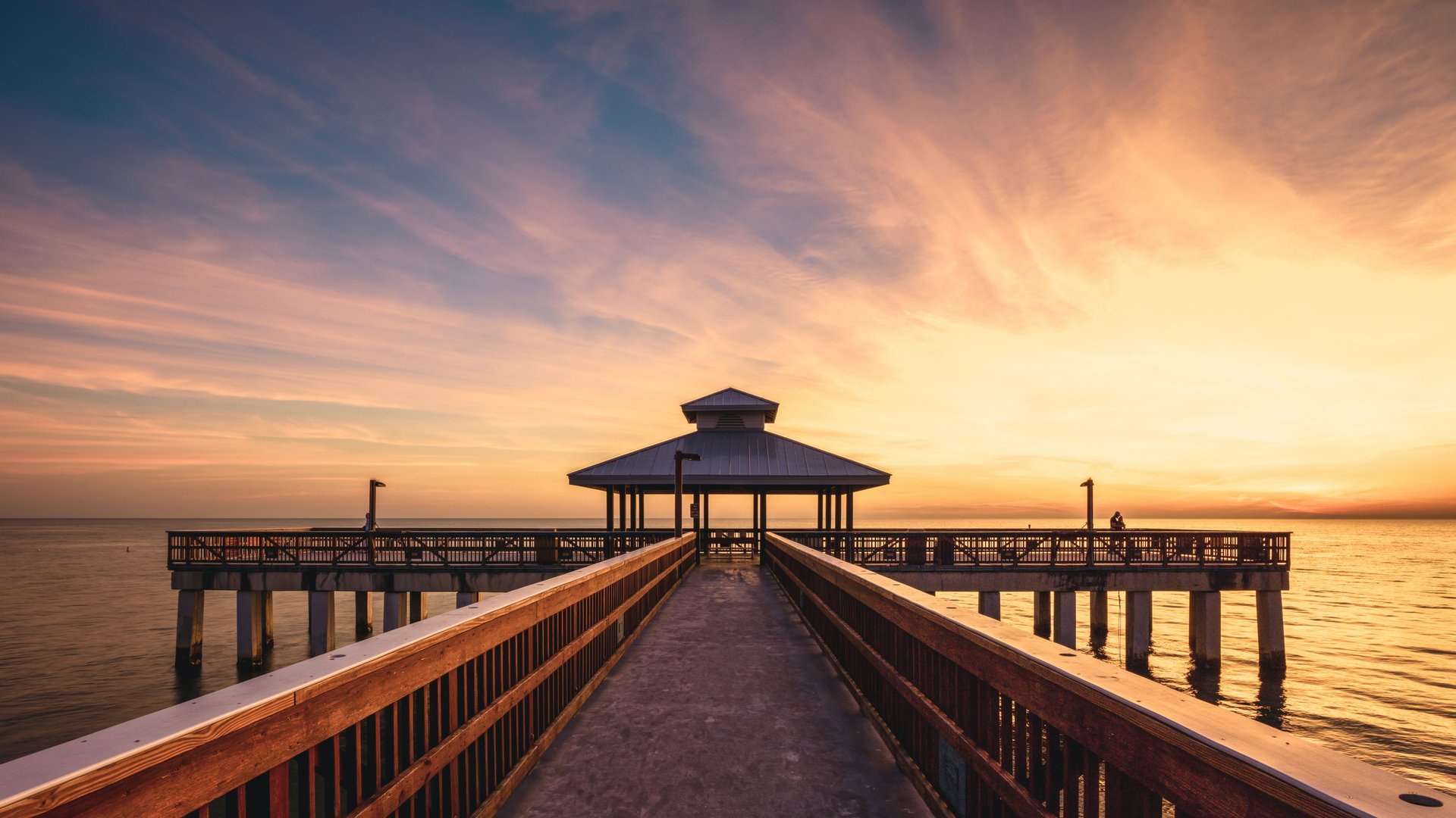Fort Myers Beach, Florida pier stretching into the Gulf at sunset, highlighting the city served by local adult day care centers.